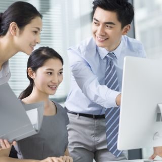 Young Chinese business people using computer in office